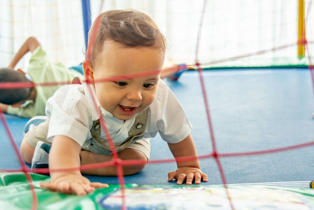 menino de um ano engatinhando em cama elástica