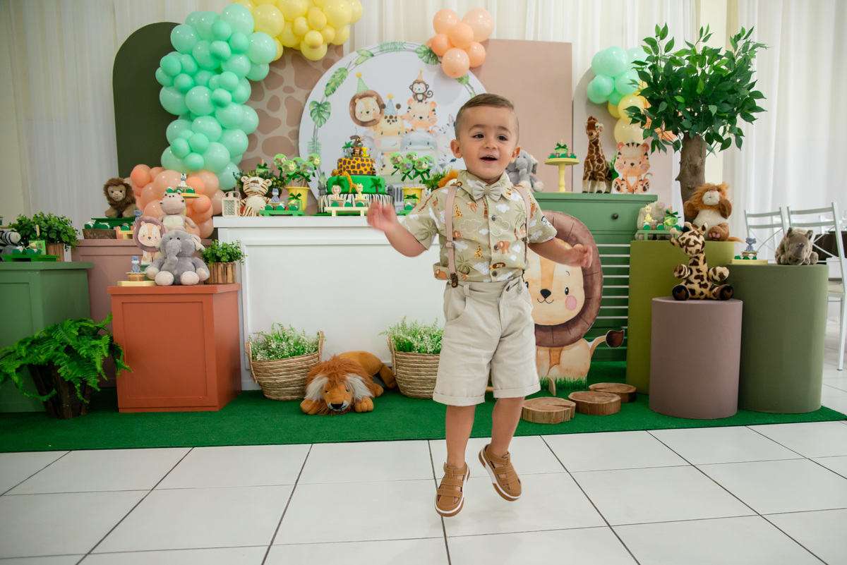 Menino de 2 anos pulando de alegria com a decoração de Safari