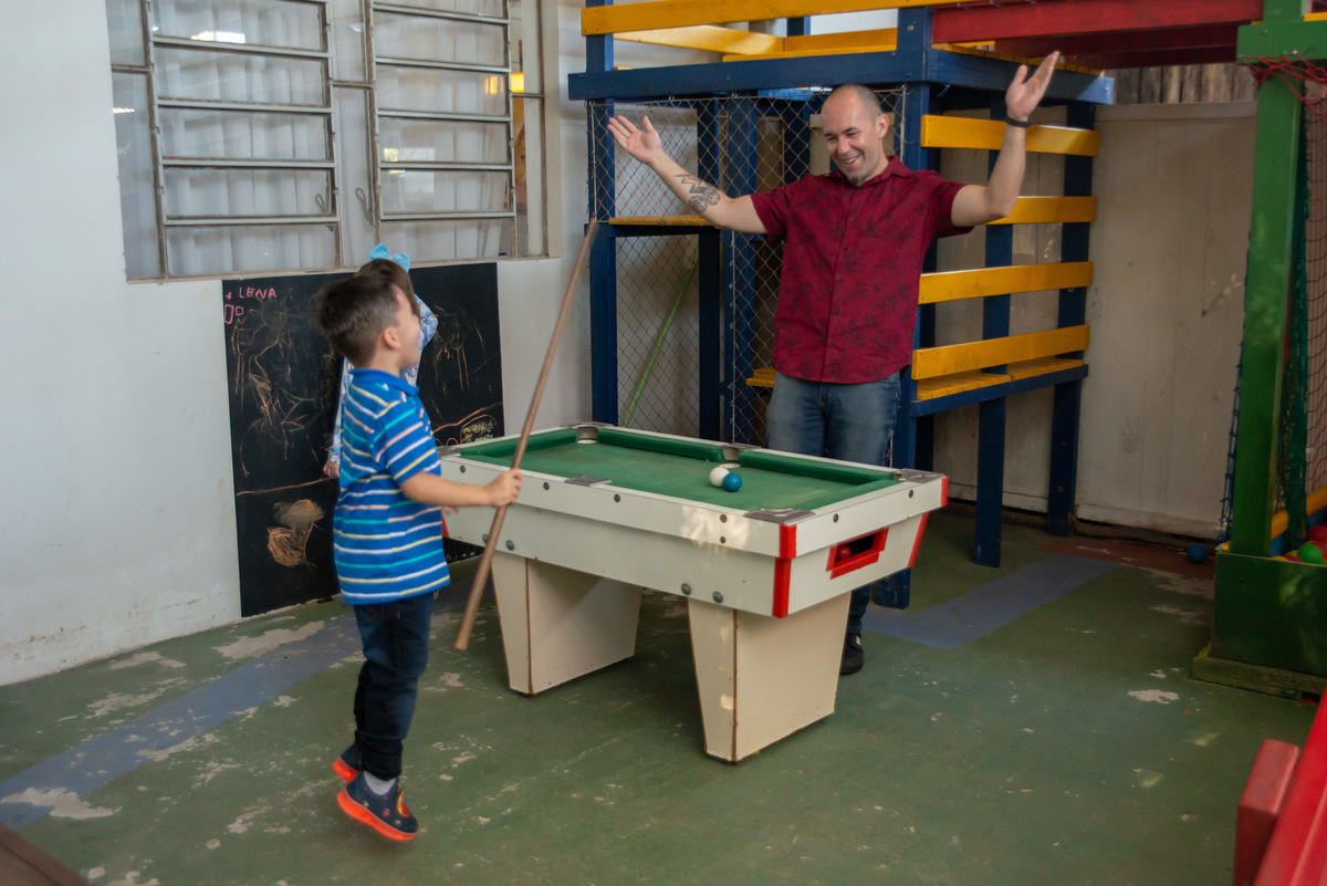 pai e filho em mesa de sinuca infantil comemorando o ponto
