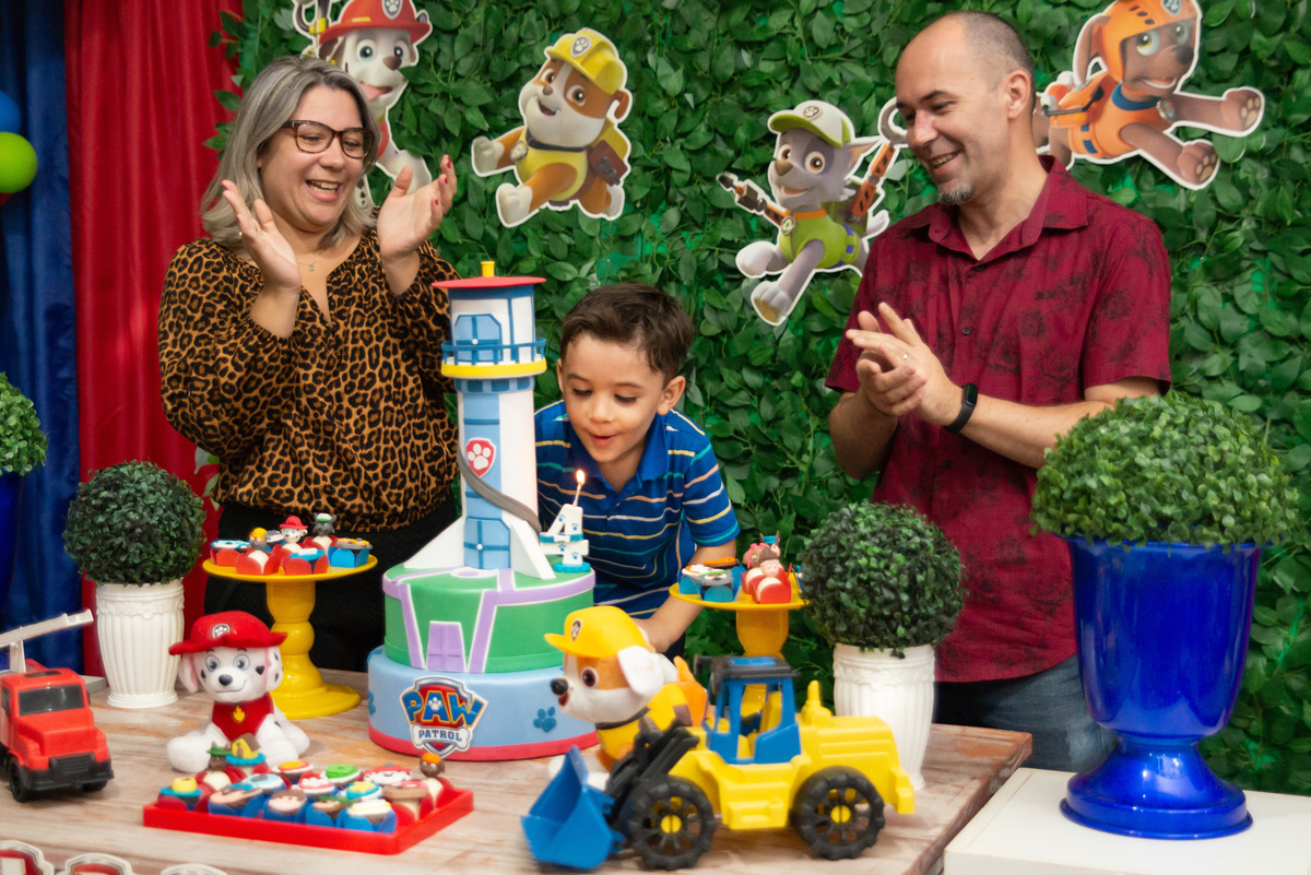 Hora de soprar a velinha na festa infantil com decoração da patrulha canina