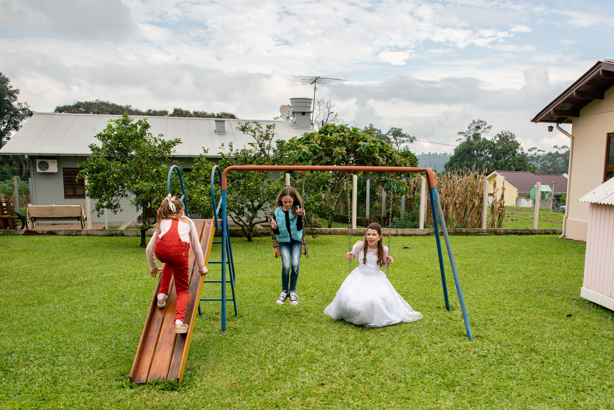 amigas brincando no balanço e escorregador - vestido de primeira comunhão