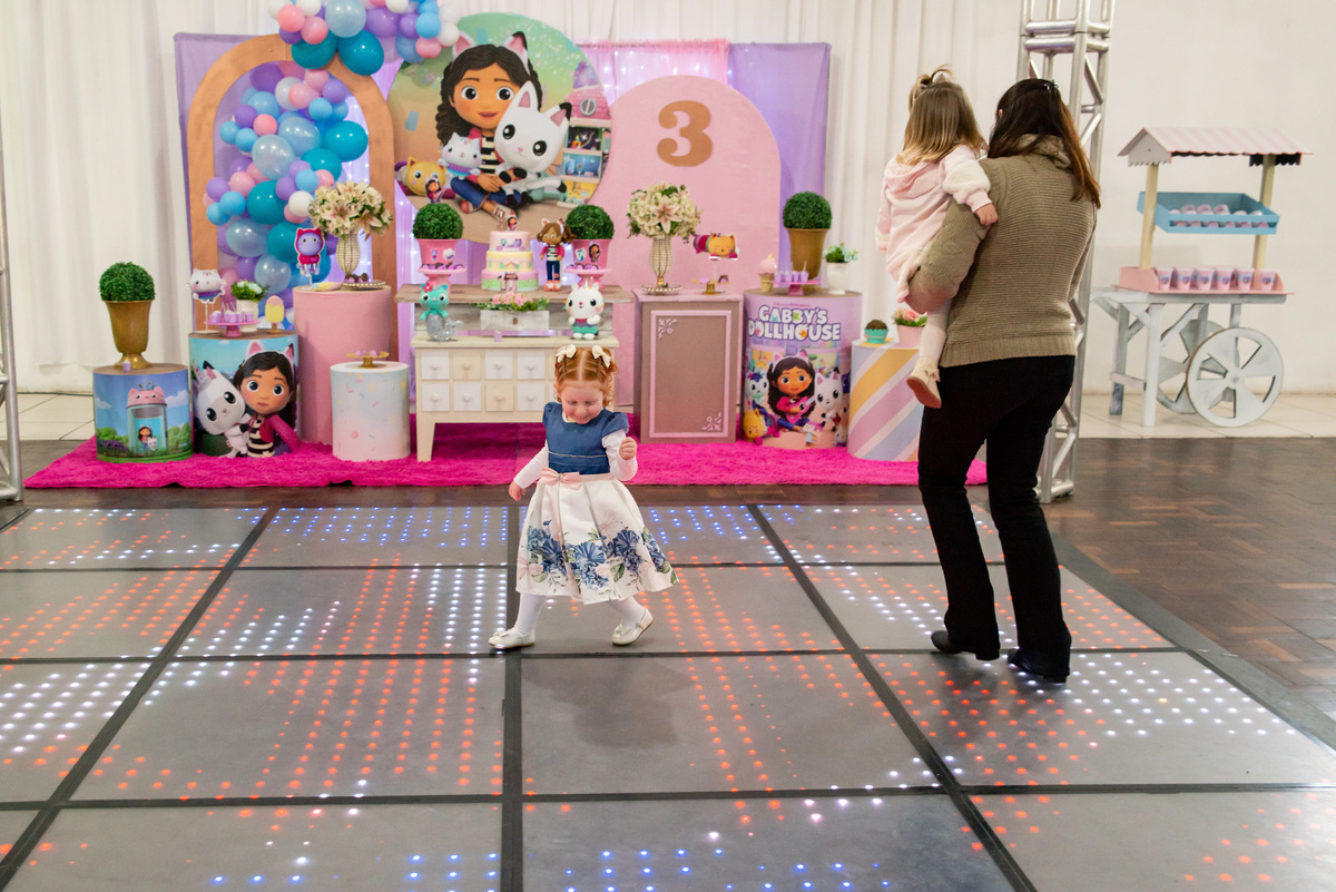menina ruiva de 3 anos em sua festa de aniversário infantil  brincando com tia e amiga, decoração da casa de bonecas da Gabby
