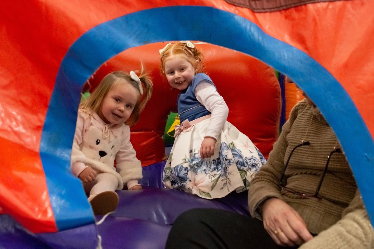 menina ruiva de 3 anos em sua festa de aniversário infantil com amiga, em brinquedo inflável
