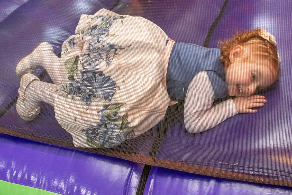 menina ruiva de 3 anos em sua festa de aniversário infantil brincando em brinquedo inflável