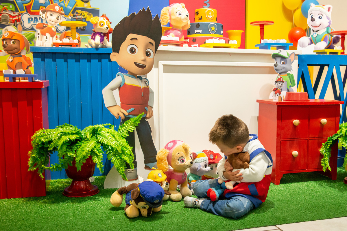 menino brincando com decoração da festa infantil da patrulha canina
