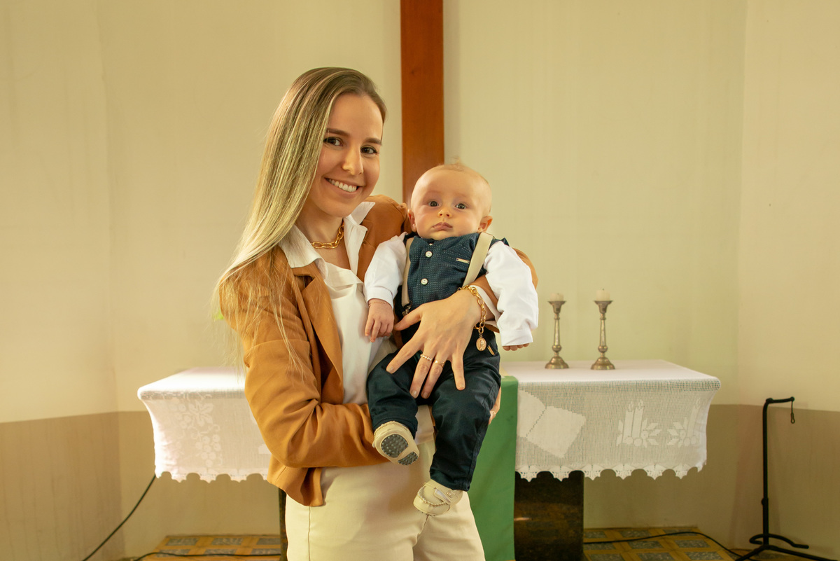 Bebê em seu batizado com a madrinha no altar da igreja - IECLB