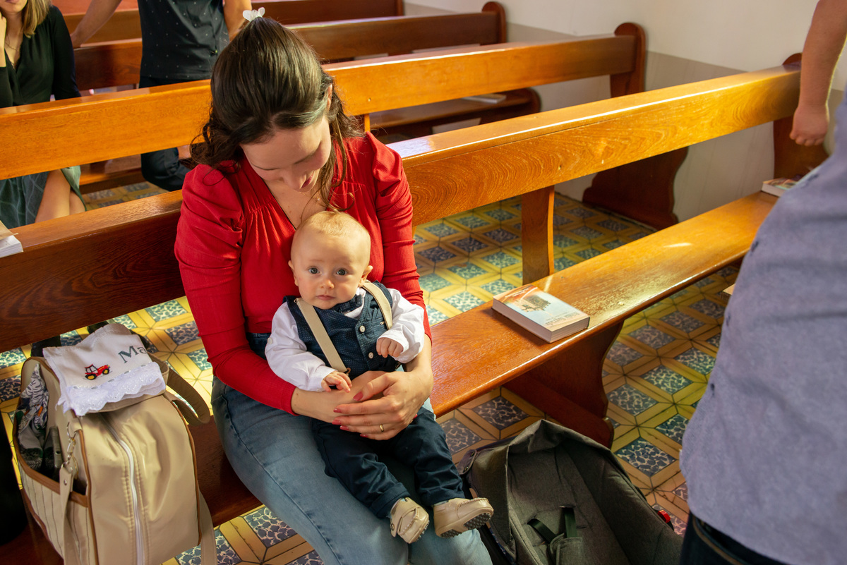 bebê no colo da mãe em banco da igreja - IECLB