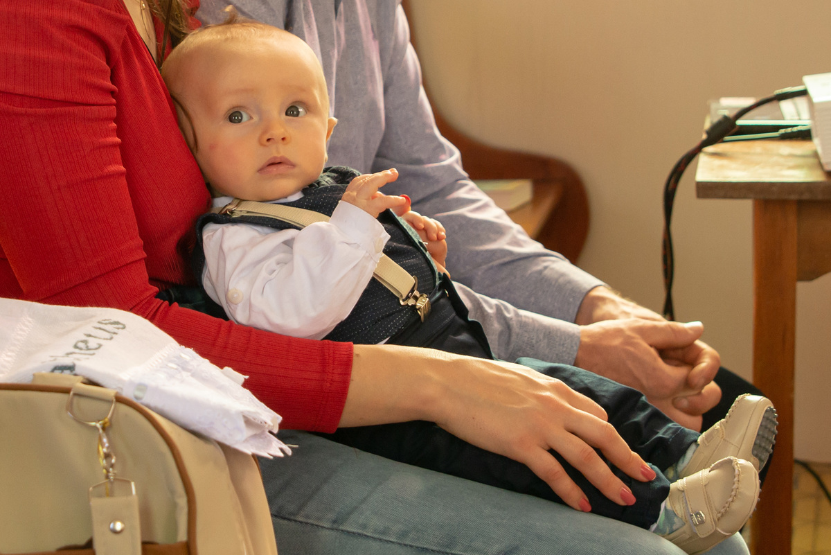 bebê no colo da mãe em banco da igreja - IECLB