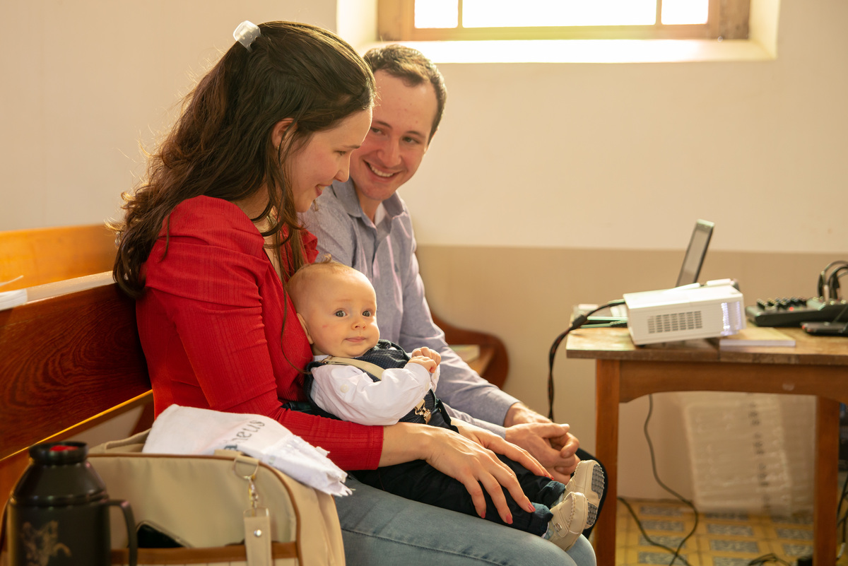 bebê no colo da mãe em banco da igreja - IECLB