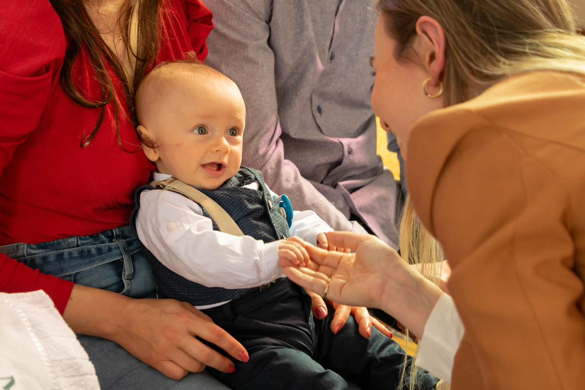 madrinha fazendo bebê rir em batizado