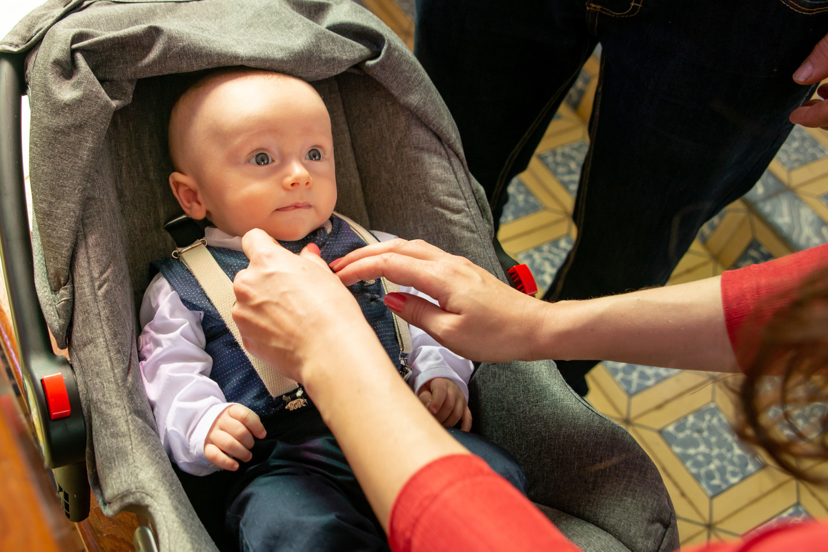 Bebê em seu batizado no bebê conforto