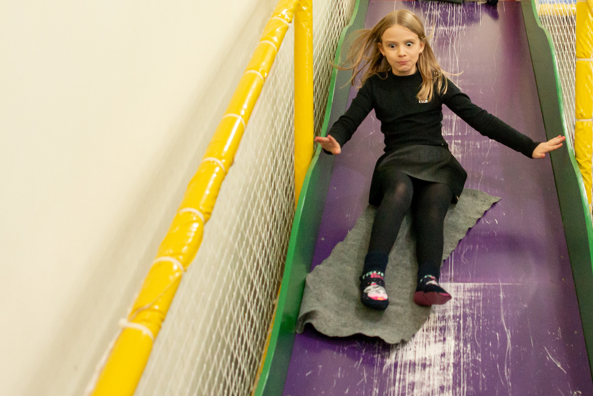 menina descendo escorregador em festa de aniversário infantil