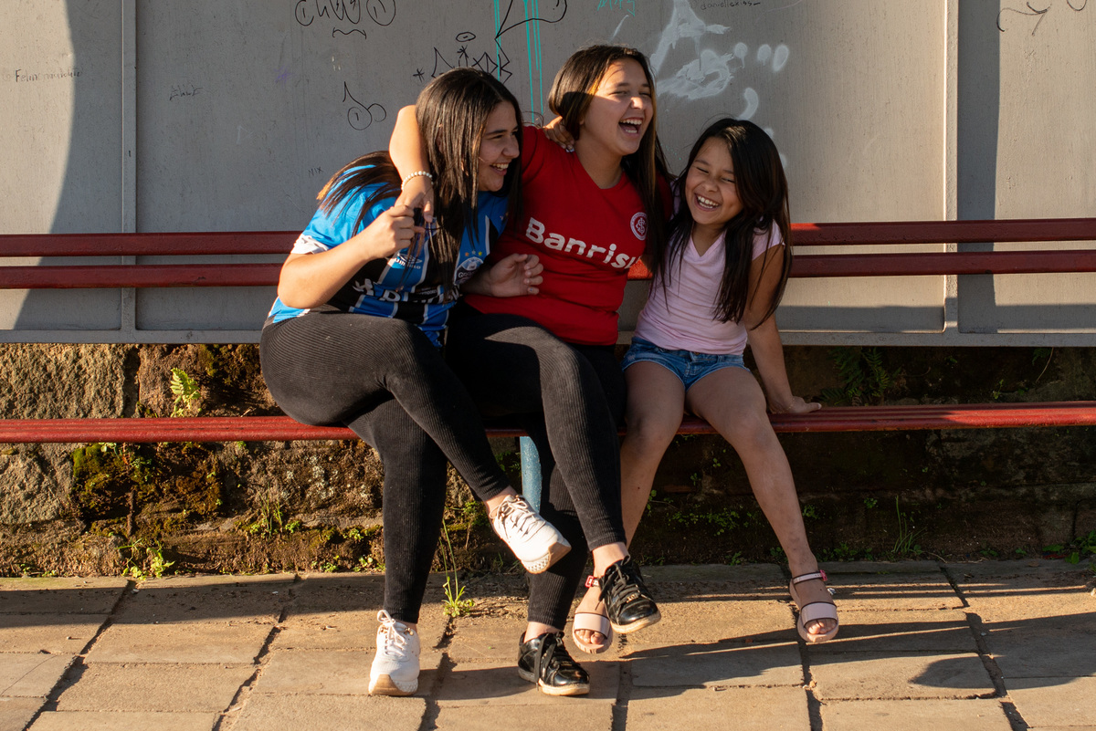 Irmãs gremistas e coloradas no ponto de ônibus