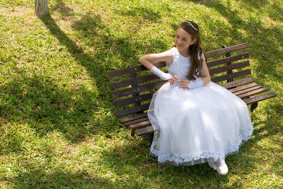 menina com vestido de primeira comunhão em ensaio externo