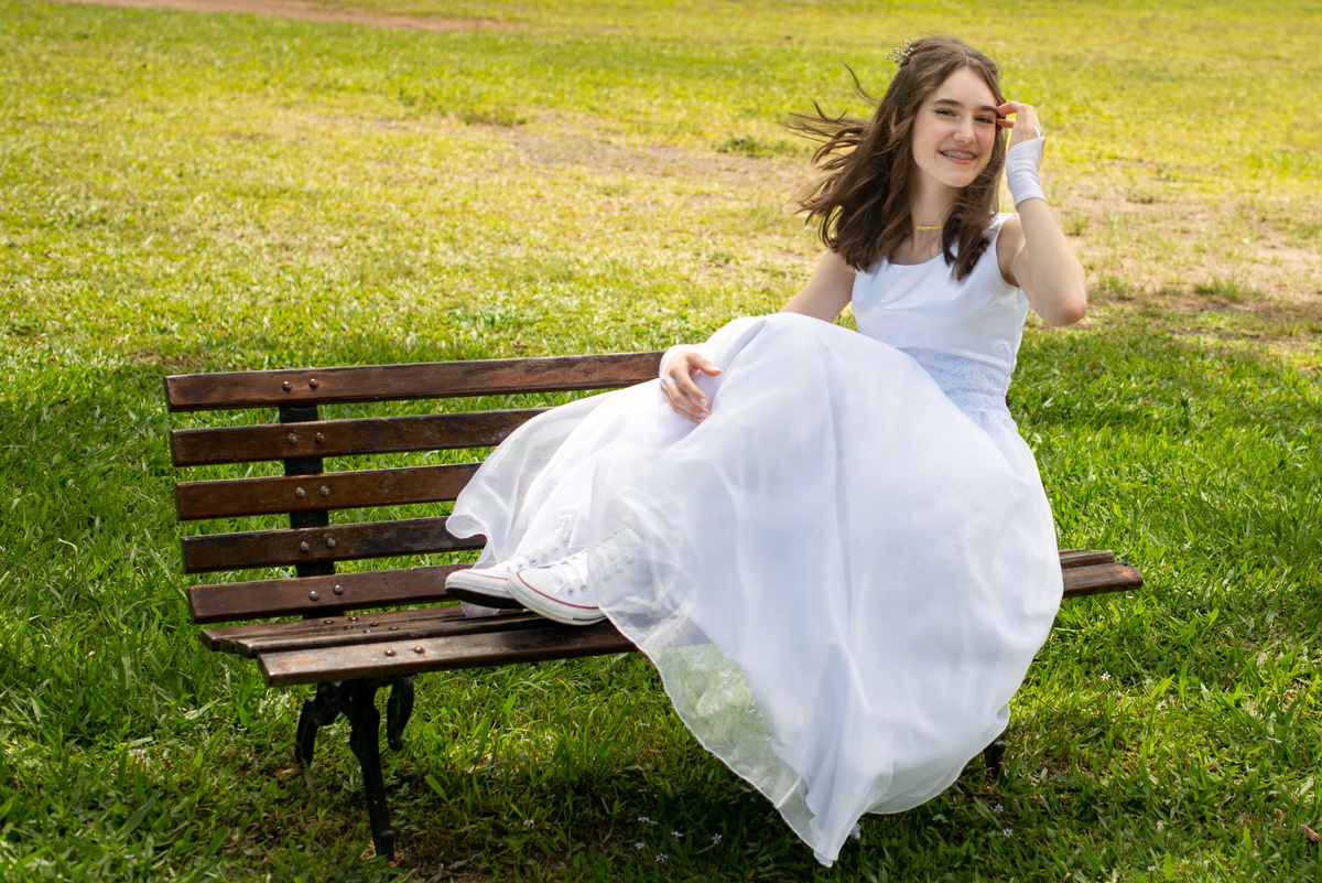 adolescente com vestido de primeira comunhão e all star