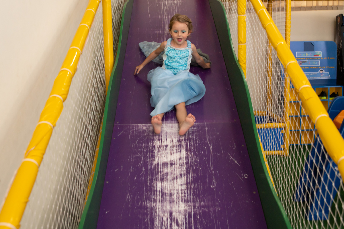 festa de aniversário infantil - aniversariante vestida de Elza Frozen - no escorregador
