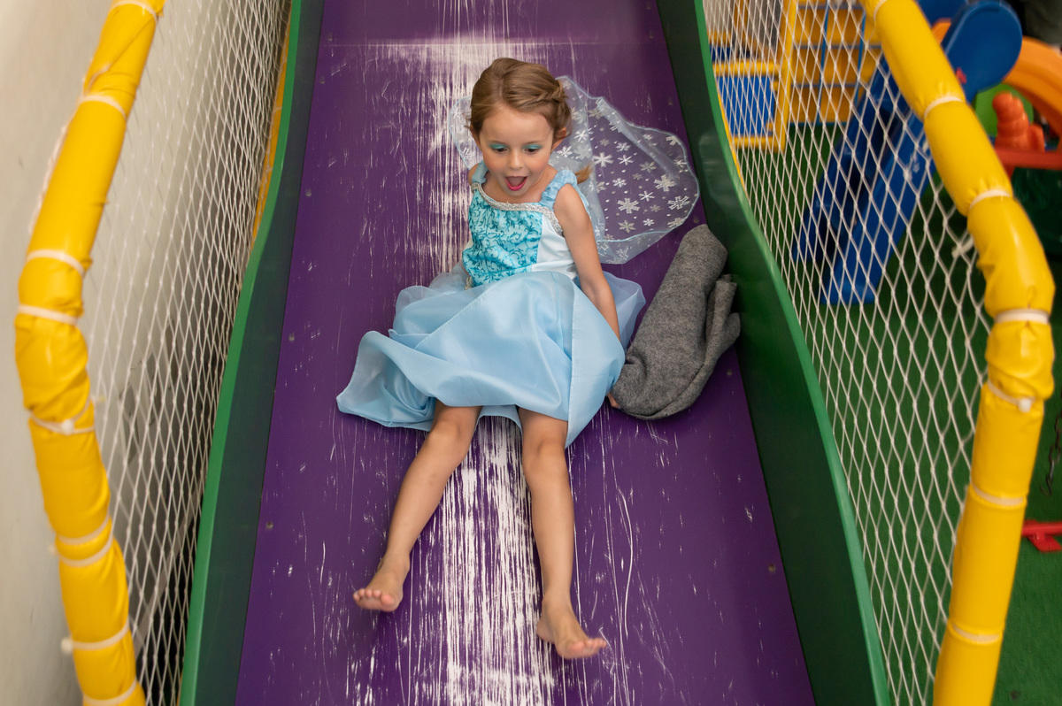 festa de aniversário infantil - aniversariante vestida Elza de Frozen - no escorregador