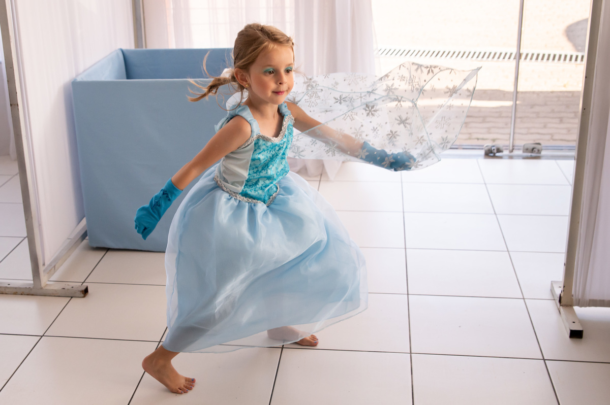 festa de aniversário infantil - aniversariante vestida de Elza - correndo no salão de festas