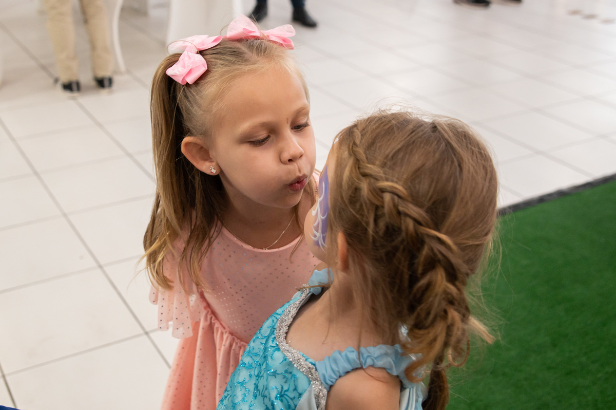 festa de aniversário infantil - aniversariante vestida de Elza - Frozen - amiga assoprando o rosto