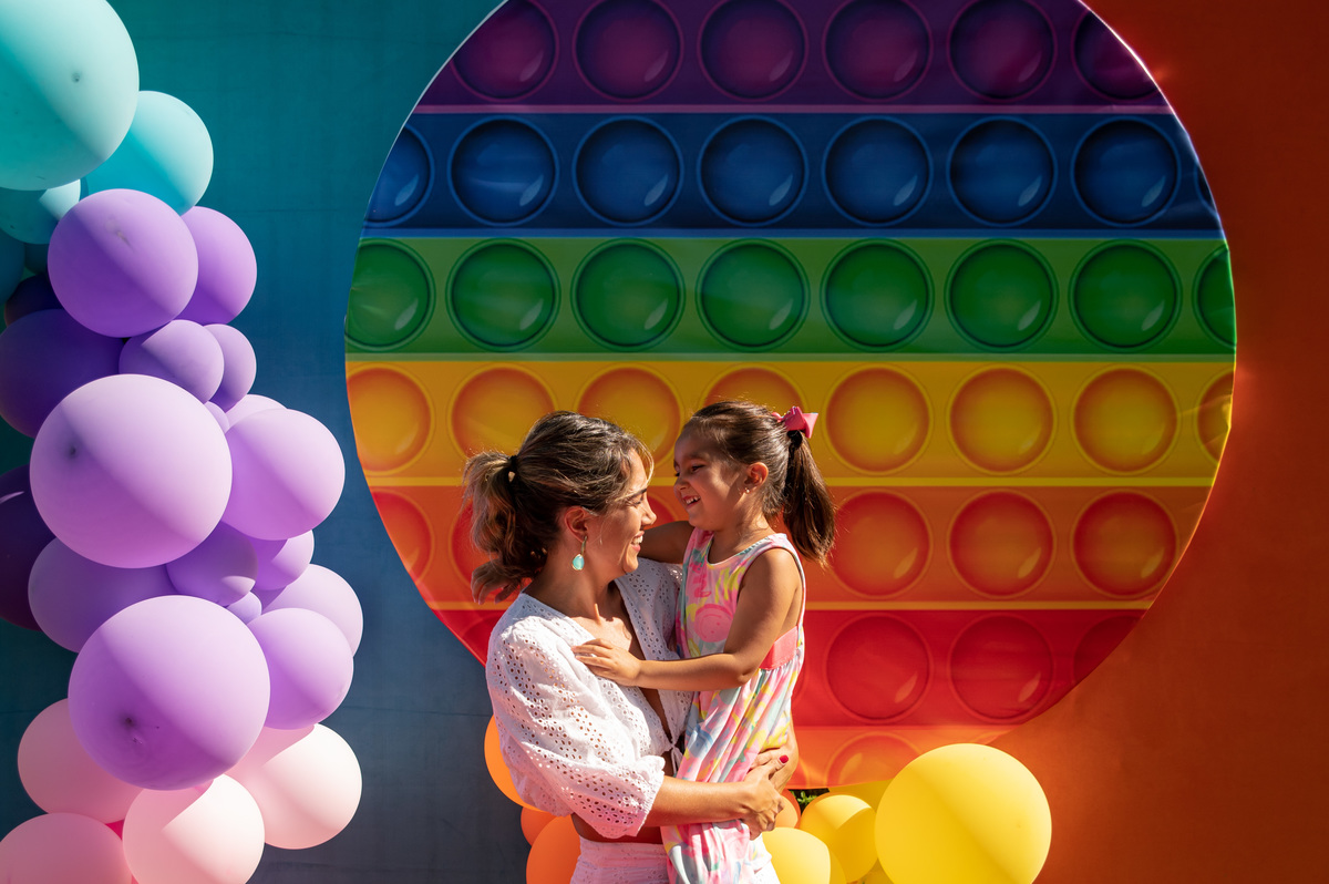 festa ao ar livre, decoração pop it, colorida - abraço e mãe e filha