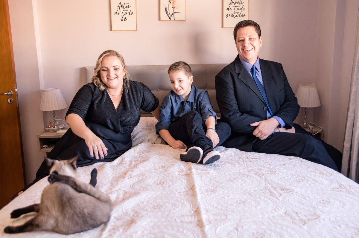 Ensaio de família em casa - família na cama do quarto com o gatinho