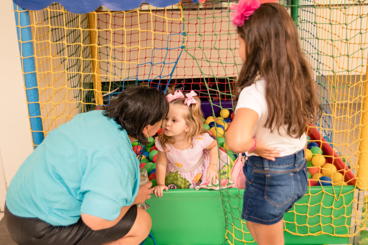 Festa infantil - criança na piscina de bolinhas ganhando carinho da vovó
