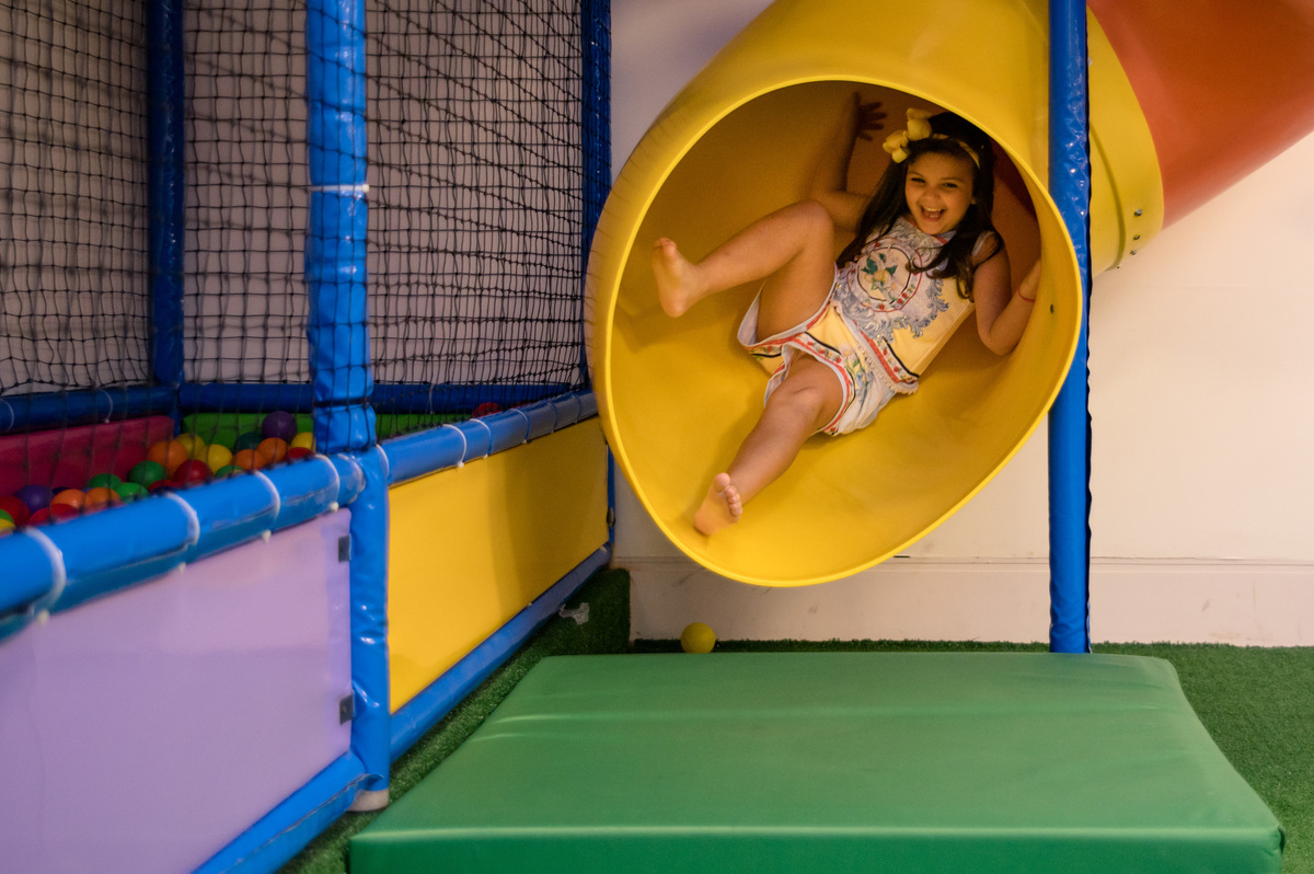 Festa de aniversário infantil, menina brincando no escorregador