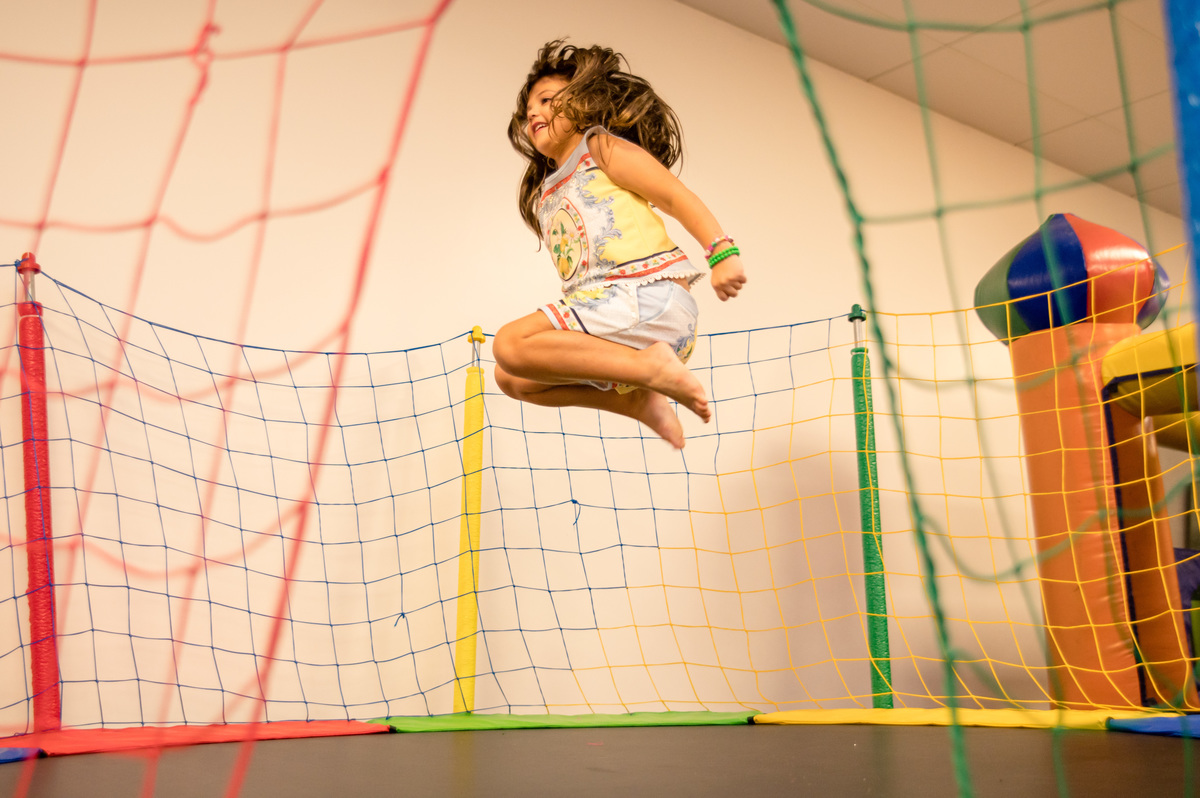 Festa de aniversário infantil, menina pulando na cama elástica