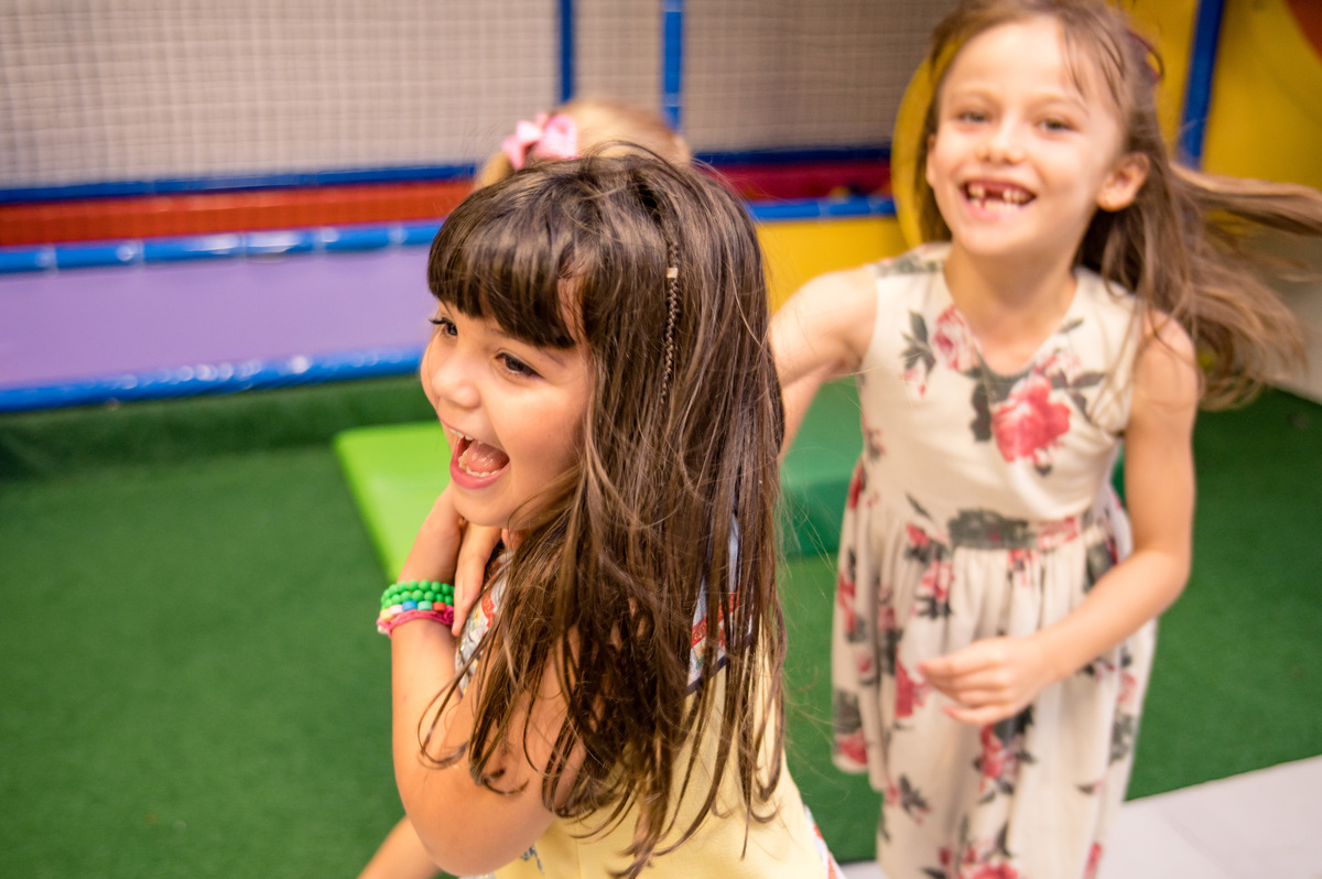 Festa de aniversário infantil, foto espontânea, meninas correndo sorridentes