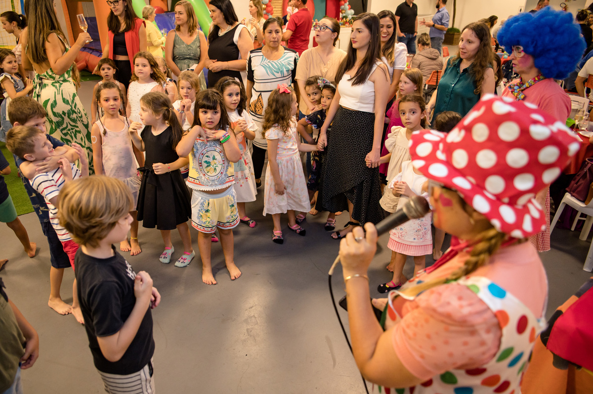 Festa de aniversário infantil, crianças dançando e brincando com palhacinhas