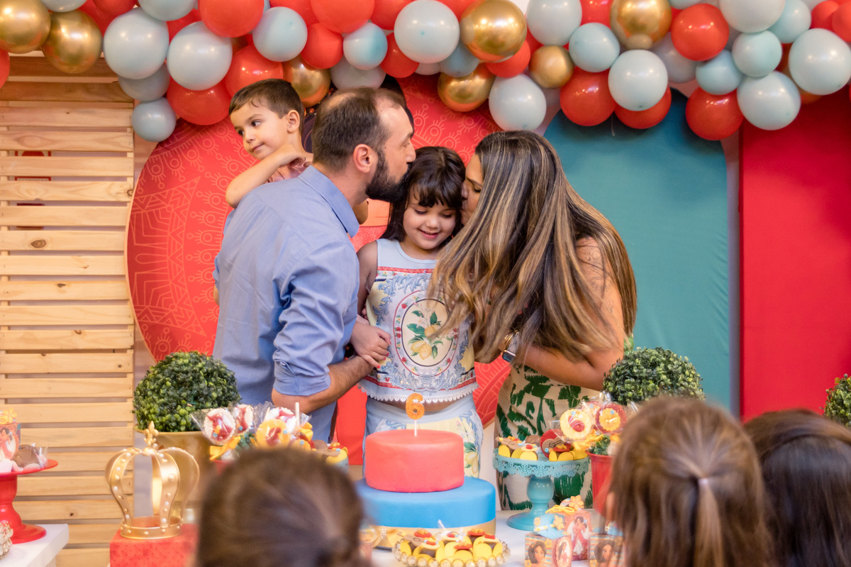 Festa de aniversário infantil, ganhando um carinho dos pais na mesa decorada Elena de Avalor