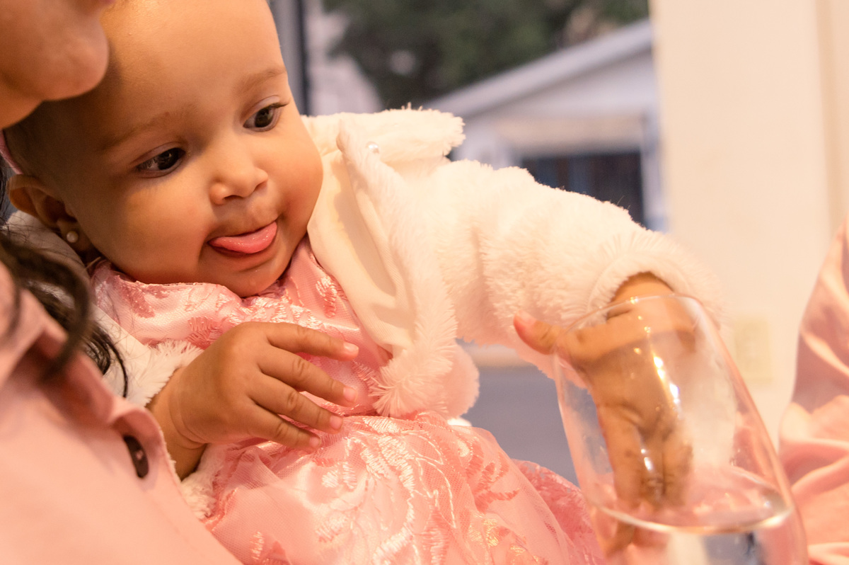 festa de aniversário infantil - foto espontânea, menina colocando a mão dentro do copo de água