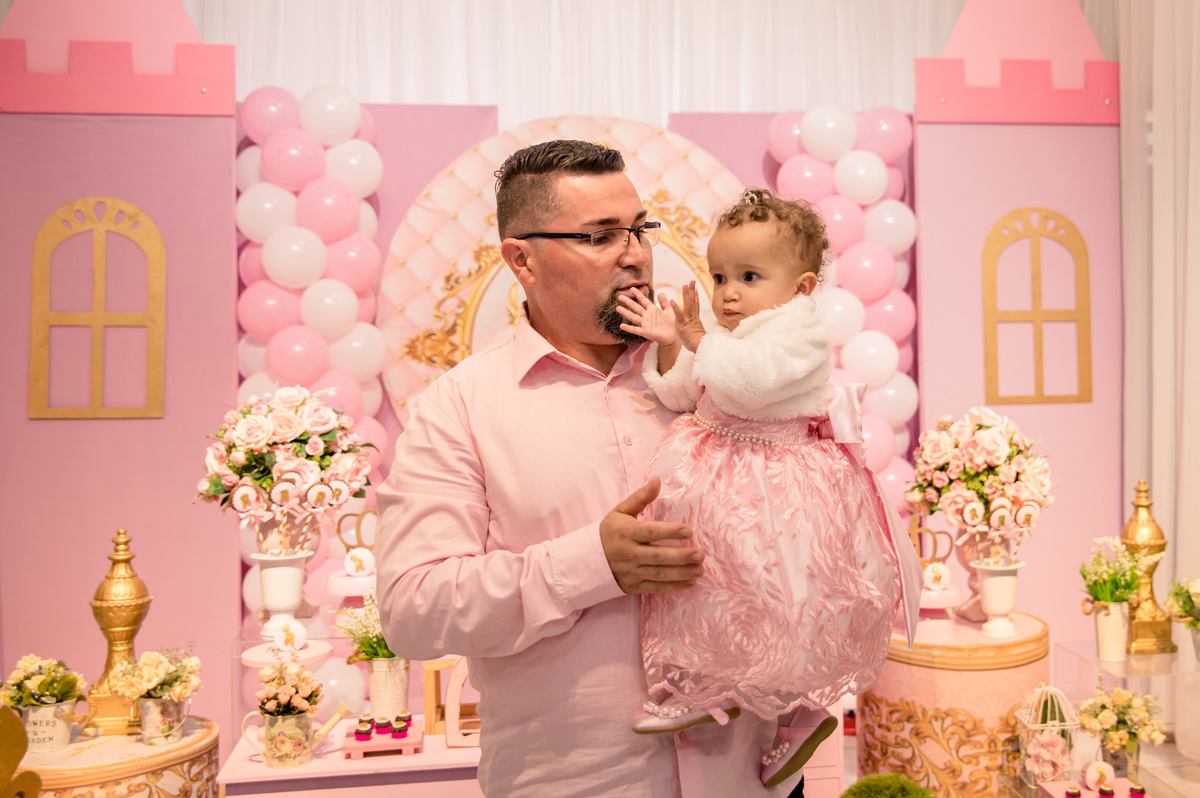 festa de aniversário infantil - decoração princesa, menina batendo palminha no colo do pai 