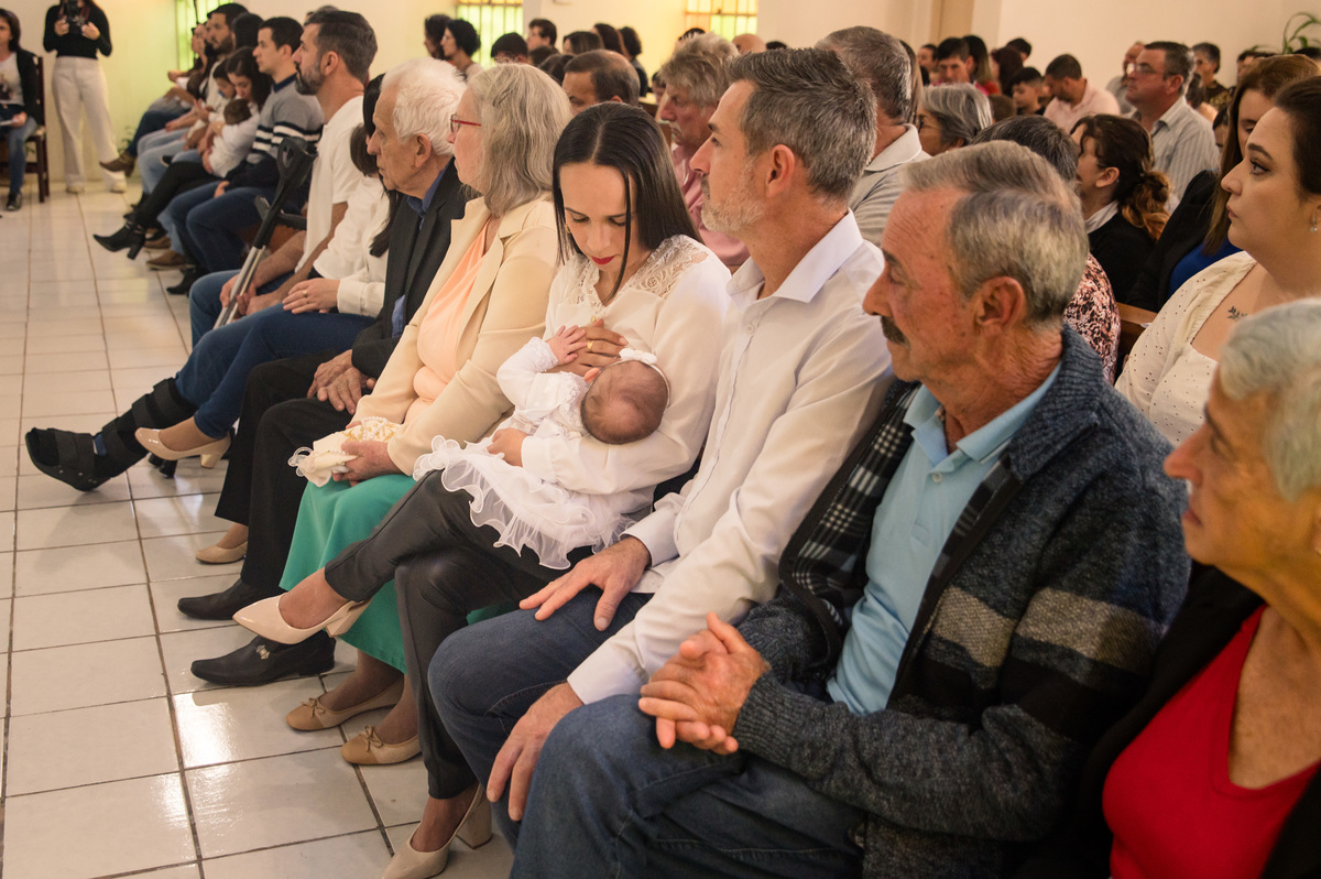 batismo batizado - bebê no colo da mãe com a família durante a missa