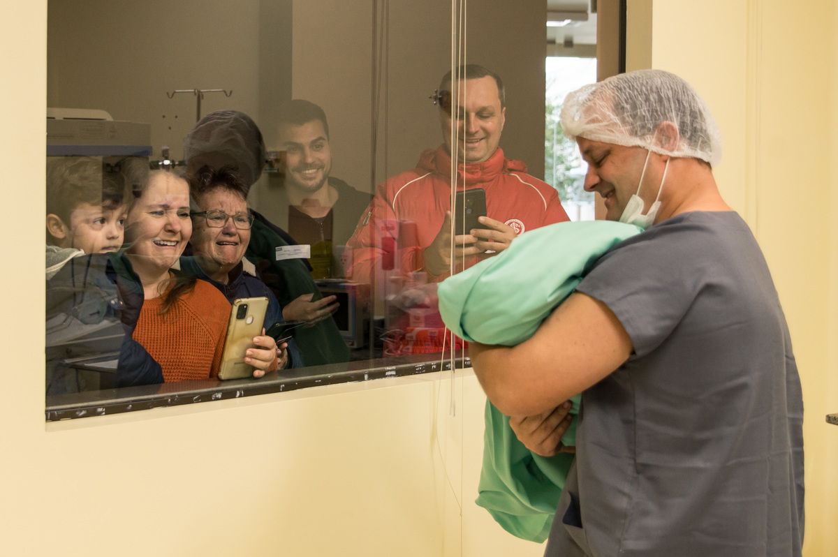 família emocionada ao ver o bebê pela primeira vez