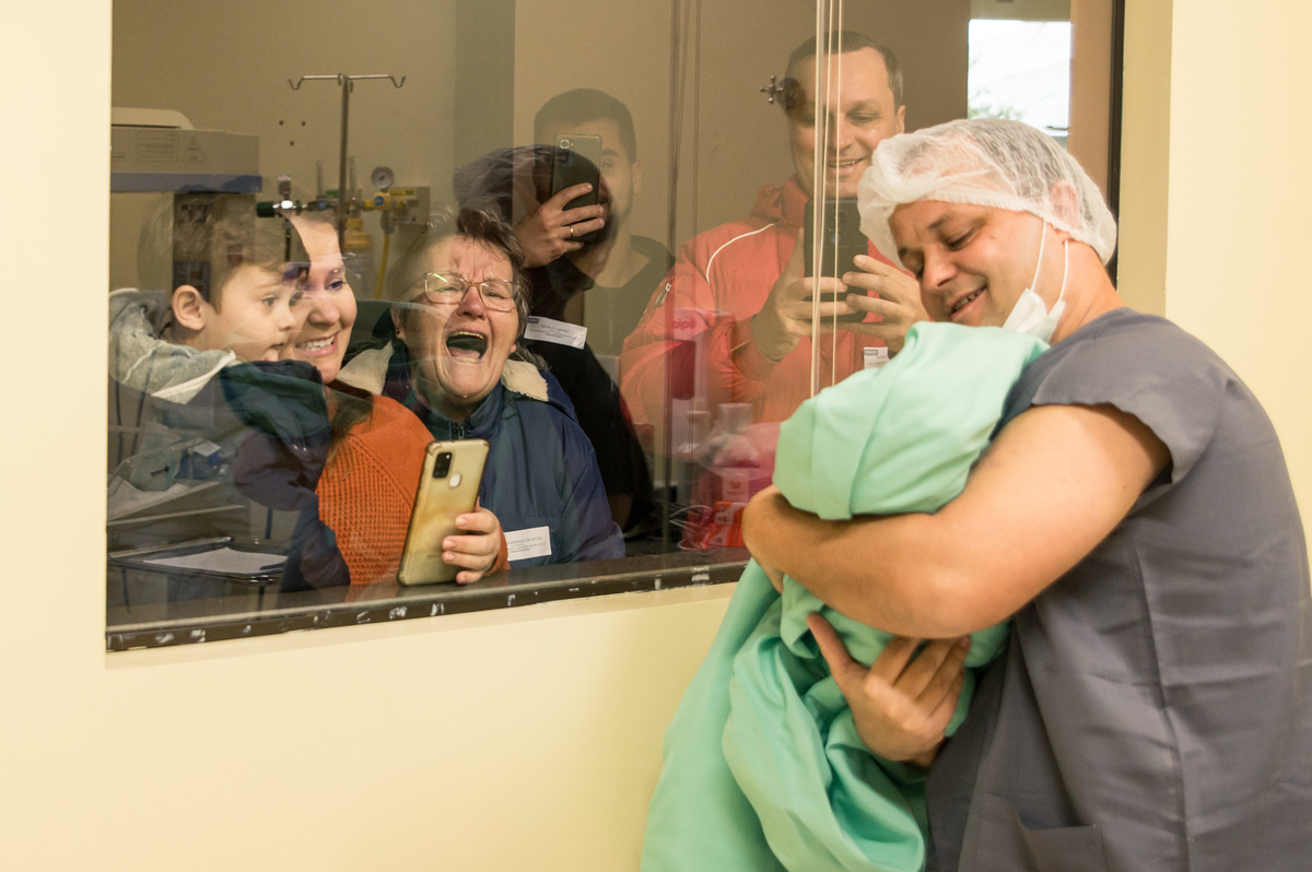 família emocionada ao ver o bebê pela primeira vez