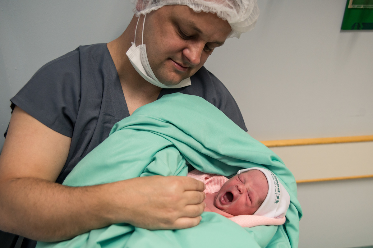 foto de nascimento, bebê bocejando no colo do pai
