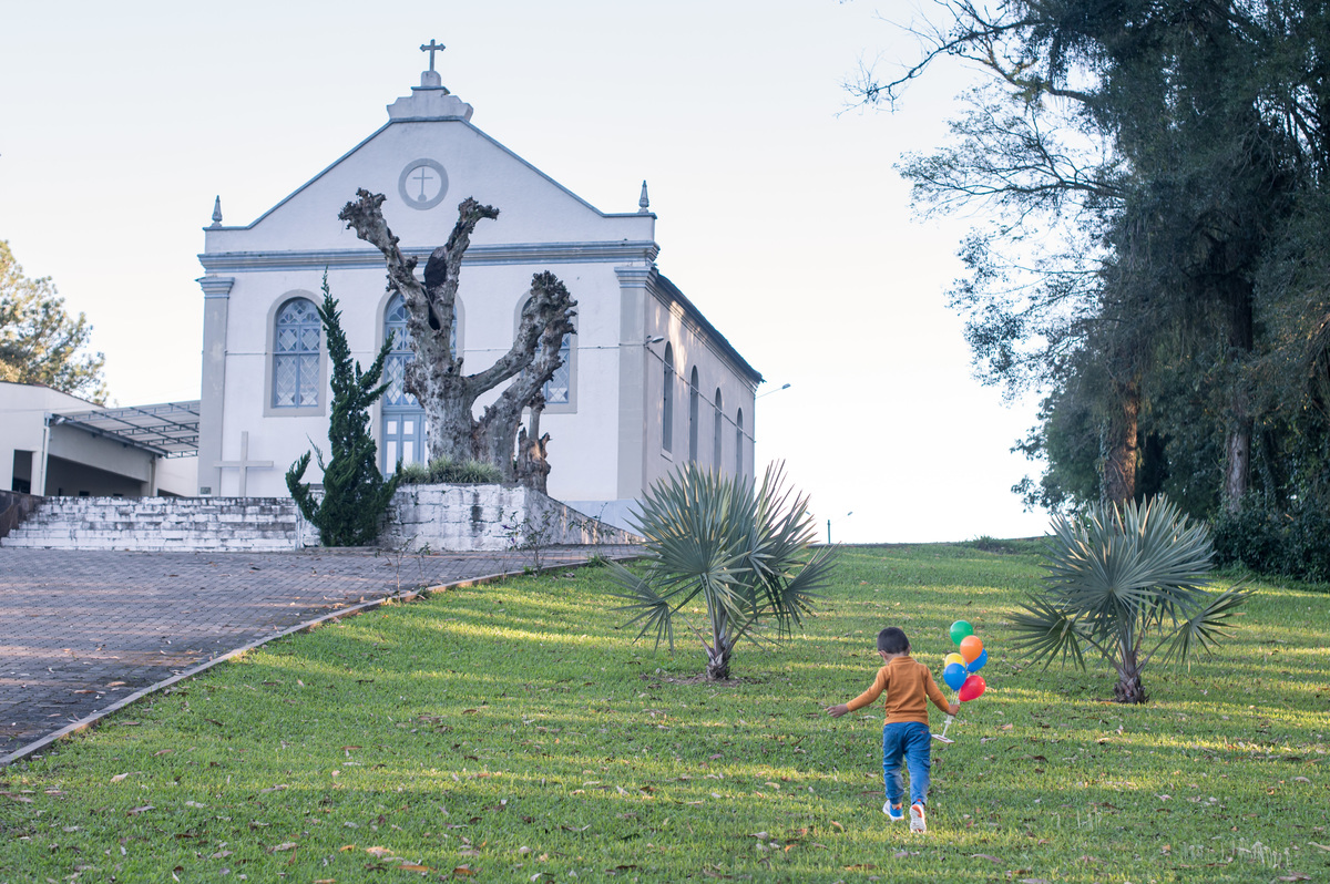 ensaio de família, criança correndo com os balões coloridos na mão