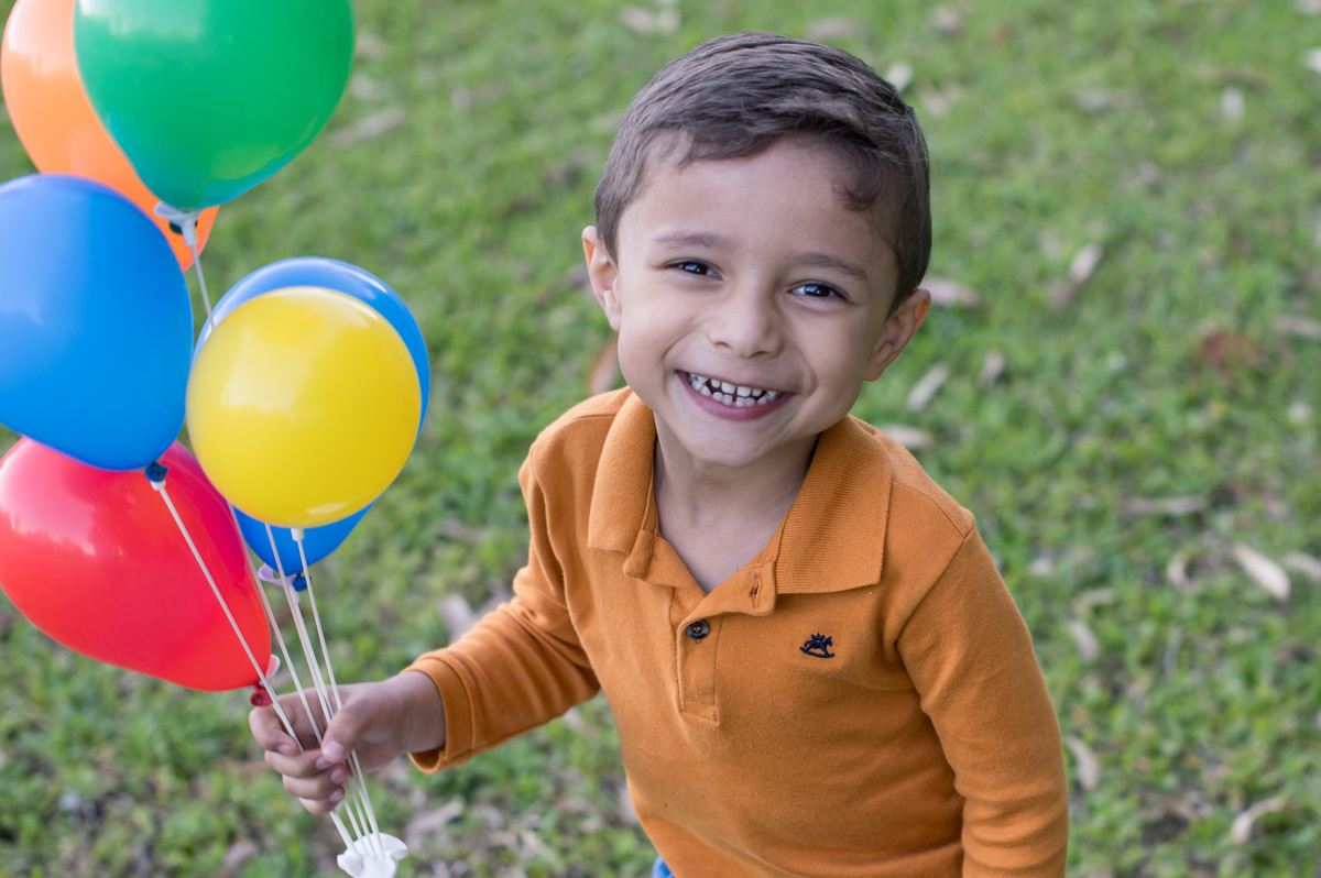 ensaio de família, criança sorrindo com balões na mão