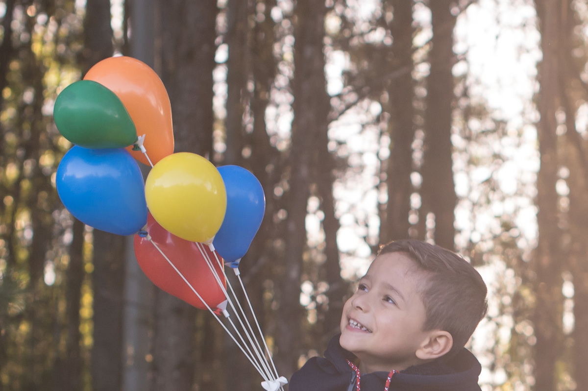 ensaio de família, criança feliz com balões, flare