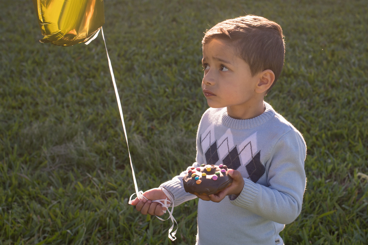 ensaio de família, criança com bolinho na mão