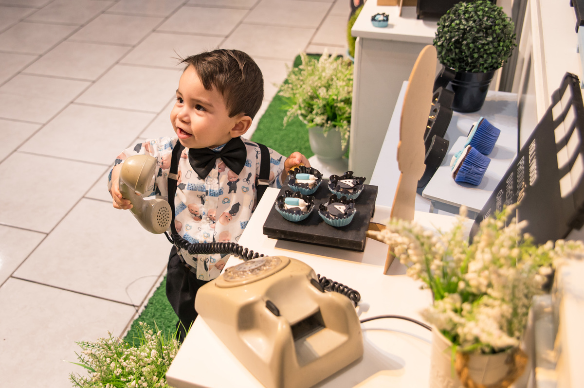 Festa de aniversário infantil - criança brincando na decoração de poderoso chefinho