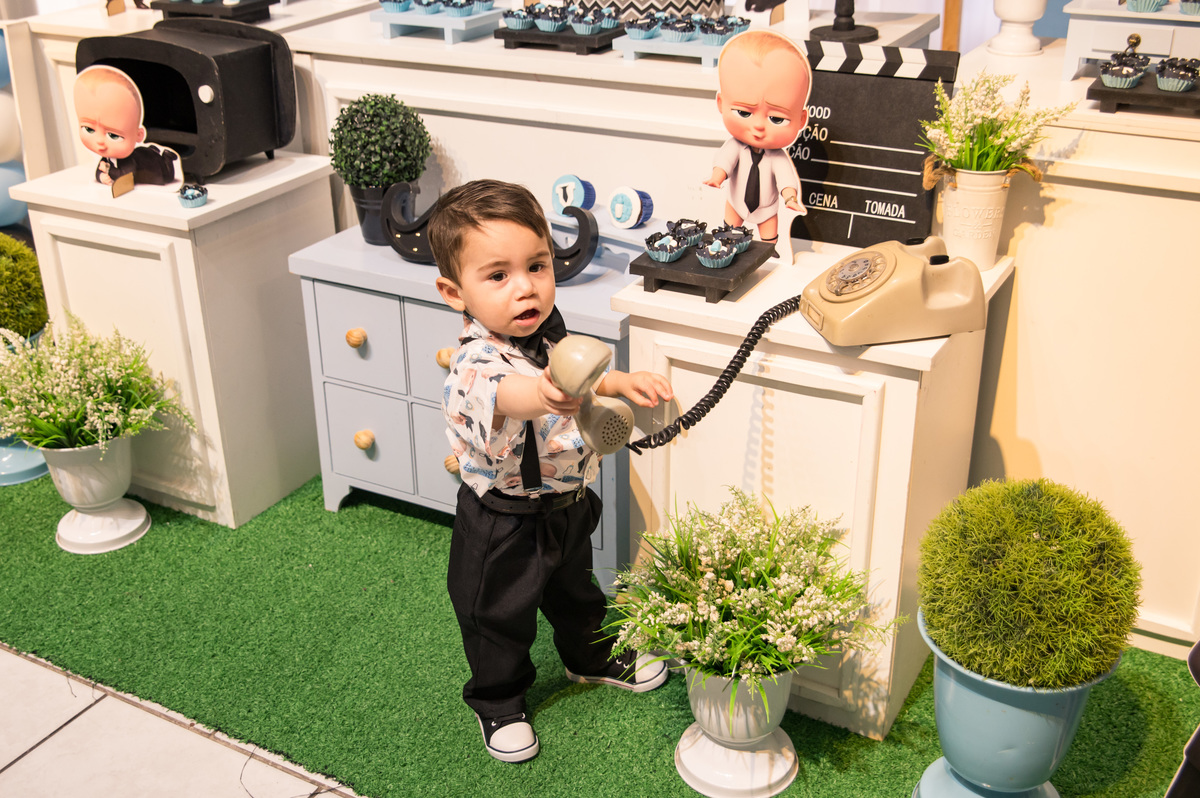 Festa de aniversário infantil - criança brincando na decoração de poderoso chefinho