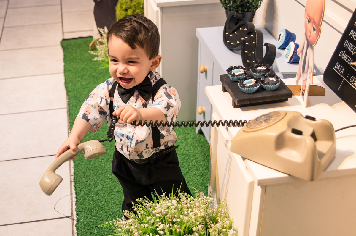 Festa de aniversário infantil - criança brincando na decoração de poderoso chefinho