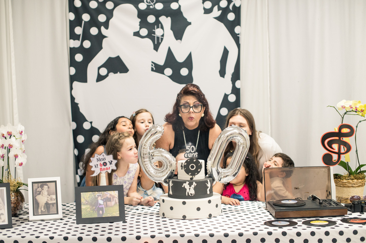 hora de assoprar as velinhas com os netos na mesa decorada dos anos 60