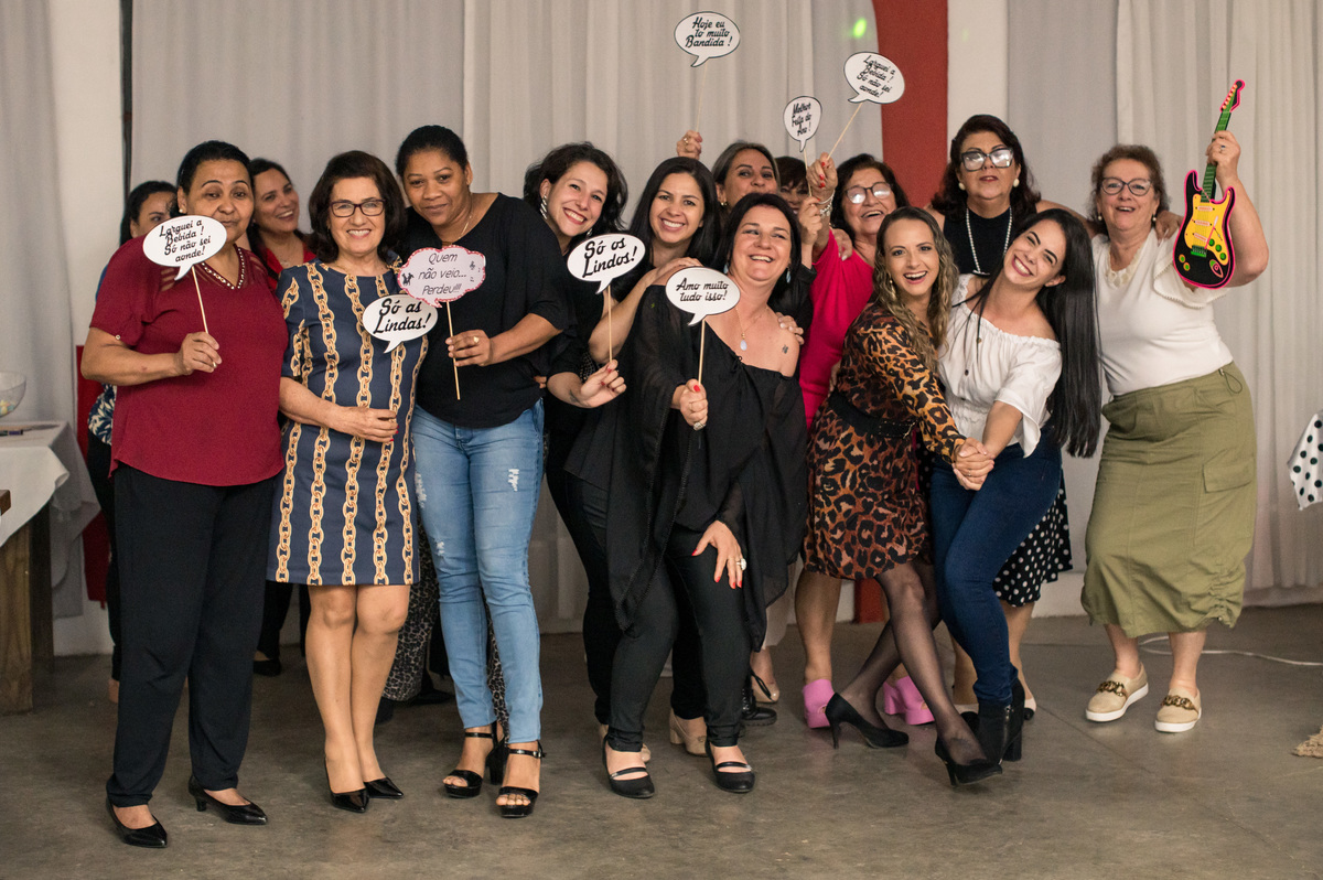 amigas se divertindo com plaquinhas na festa de 60 anos