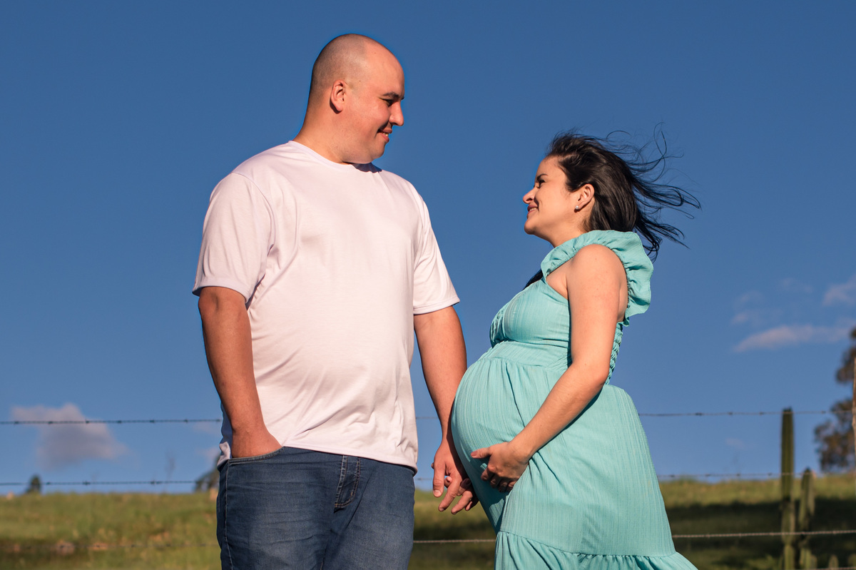Ensaio de gestante da chácara  - pai e mãe com o céu azul de fundo