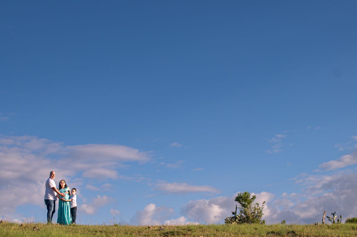 Ensaio de gestante da chácara  - foto da família bem de longe, com céu azul