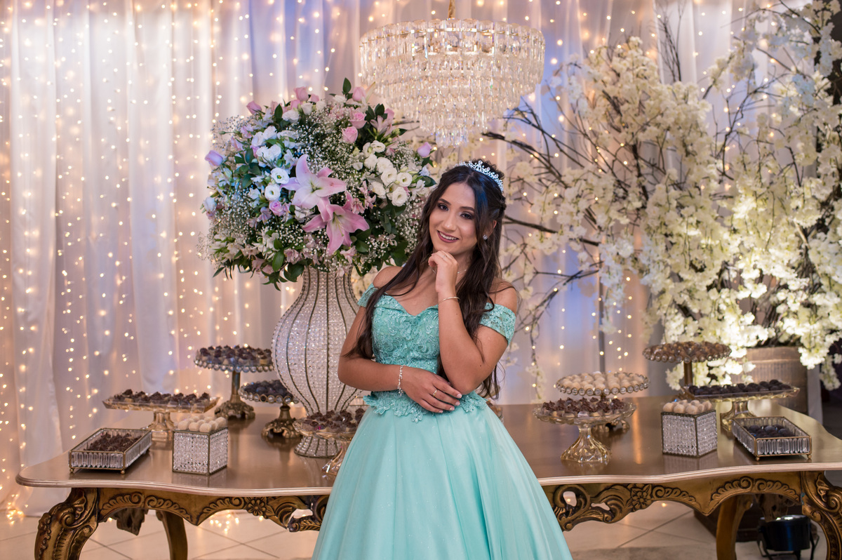 menina de 15 anos fazendo pose para foto na mesa da festa