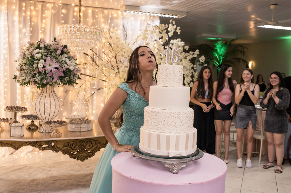 assoprando a vela do bolo de aniversário de 15 anos